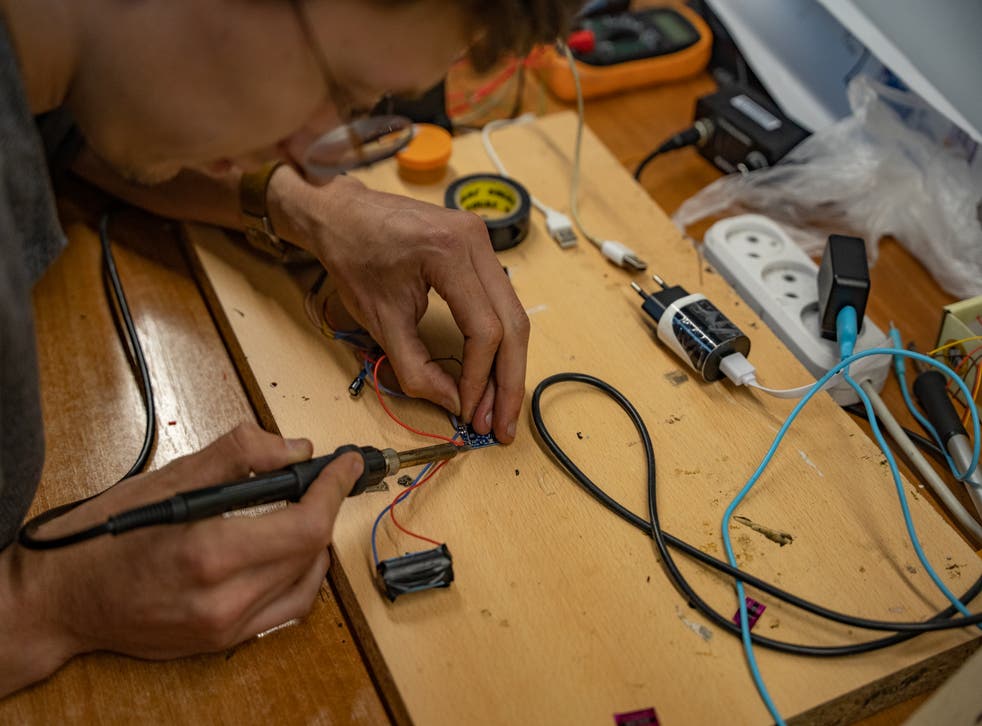 <p>Maksym Sheremet solders a release device for a drone using a battery from an e-cigarette</p>