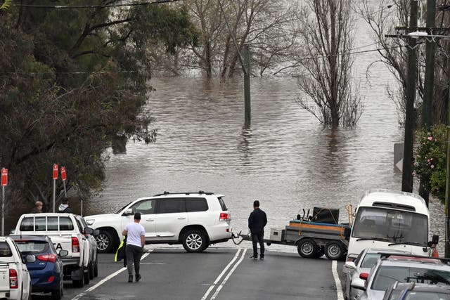 Locals save furniture from a house threatened by floodwaters in Camden in Sydney, Austrália