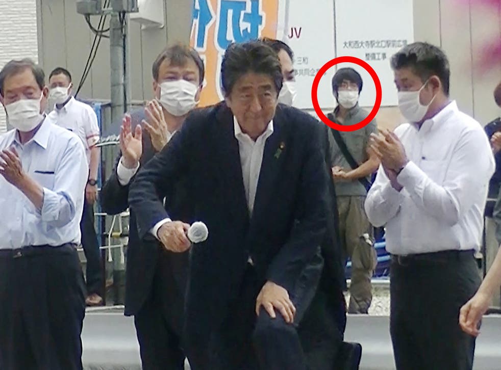 <p>Shinzo attending an election campaign before giving a speech at Kintetsu Yamato-Saidaiji station square in Nara, while a man suspected of shooting Abe shortly after stands in the background</p>