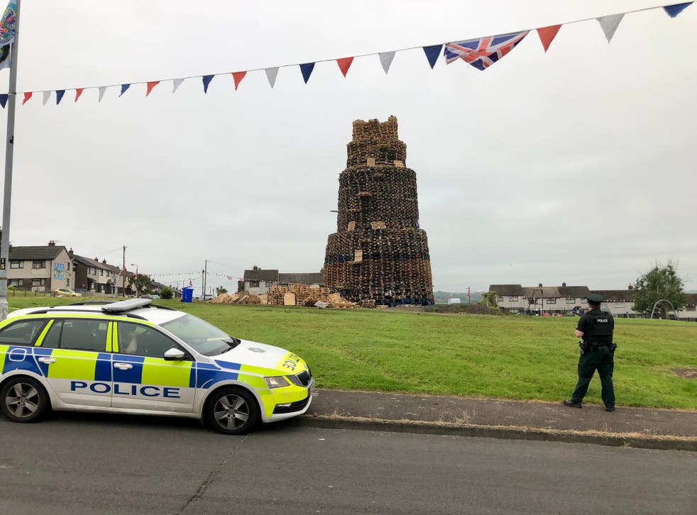 Police at the scene of the fatal fall at a bonfire in Larne (PA)