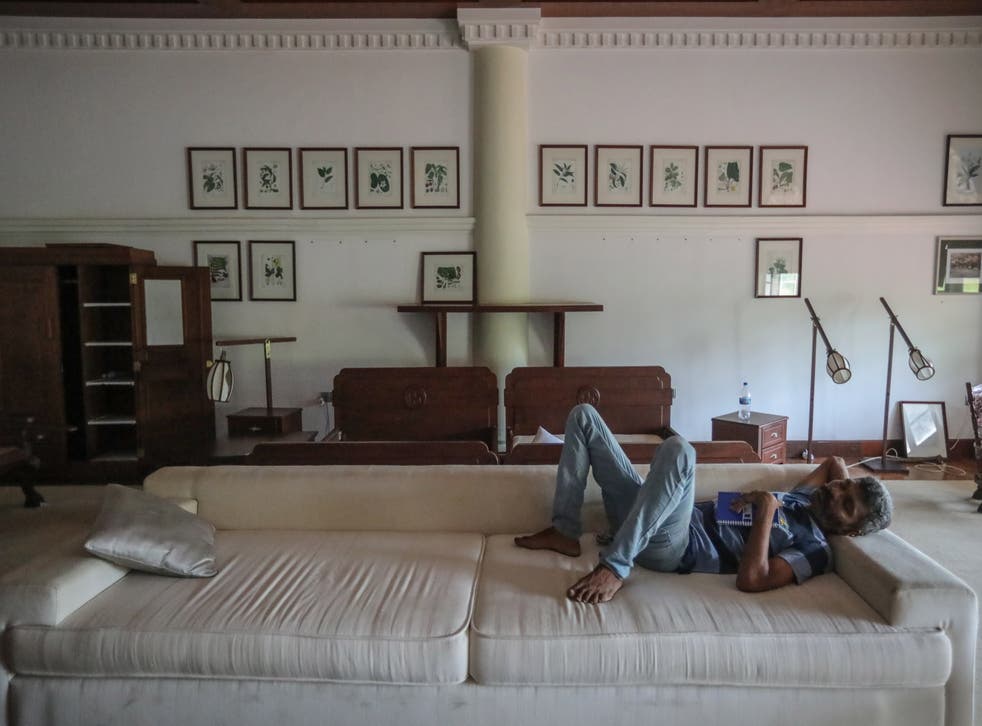 <p>A man sleeps on a couch at the prime minister's official residence in Colombo</p>
