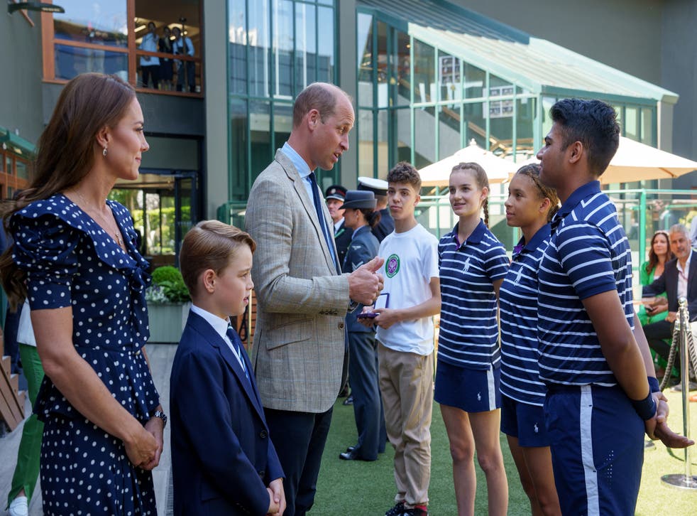 The Duke and Duchess of Cambridge, with Prince George, speak to ball boys and ball girls (PA)