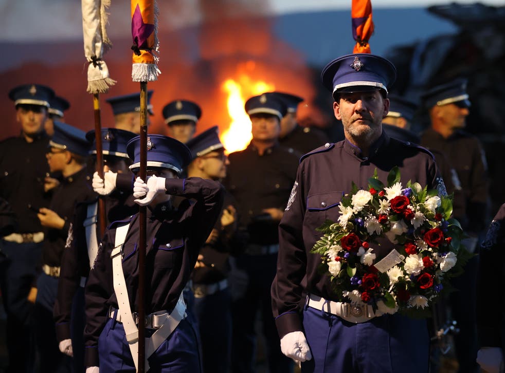 The Cairncastle Flute Band leader with a wreath before laying it during the vigil (Liam McBurney/PA)