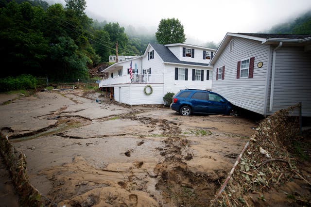 A house that was moved off of its foundation following a flash flood rests on top of a vehicle in Whitewood, Virginia, USA