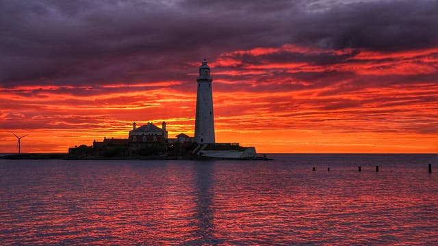 A fire coloured sky above St Mary’s Lighthouse in Whitley bay on the North East coast of England just before sunrise