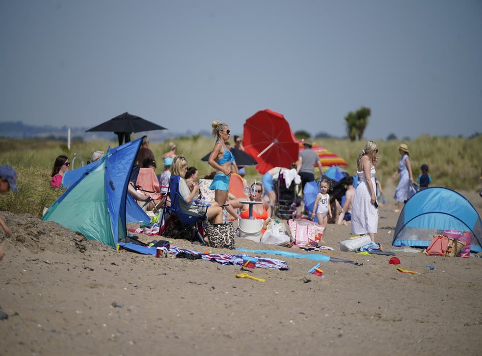 People enjoying the weather and trying to keep cool at Malahide beach near Dublin (Niall Carson/PA)
