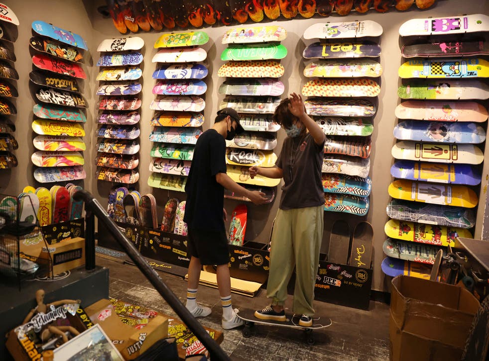 <p>A customer tries on a surfskateboard at the Burning Ice Skateboard shop, in Beijing</磷>