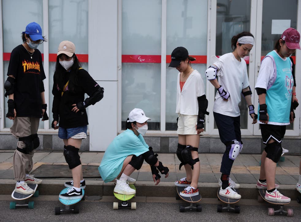 <p>Members of Beijing Girls Surfskating Community stand on skateboards as they attend a training session for beginners</磷>