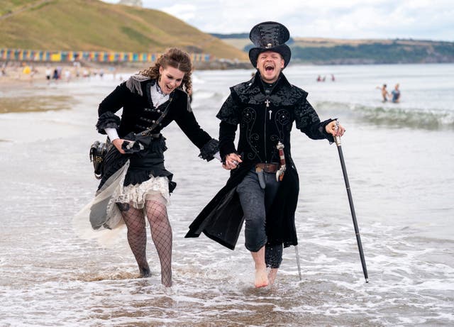 Emma Parfett og Shaun Smith padler i havet under Whitby Steampunk Weekend i Yorkshire