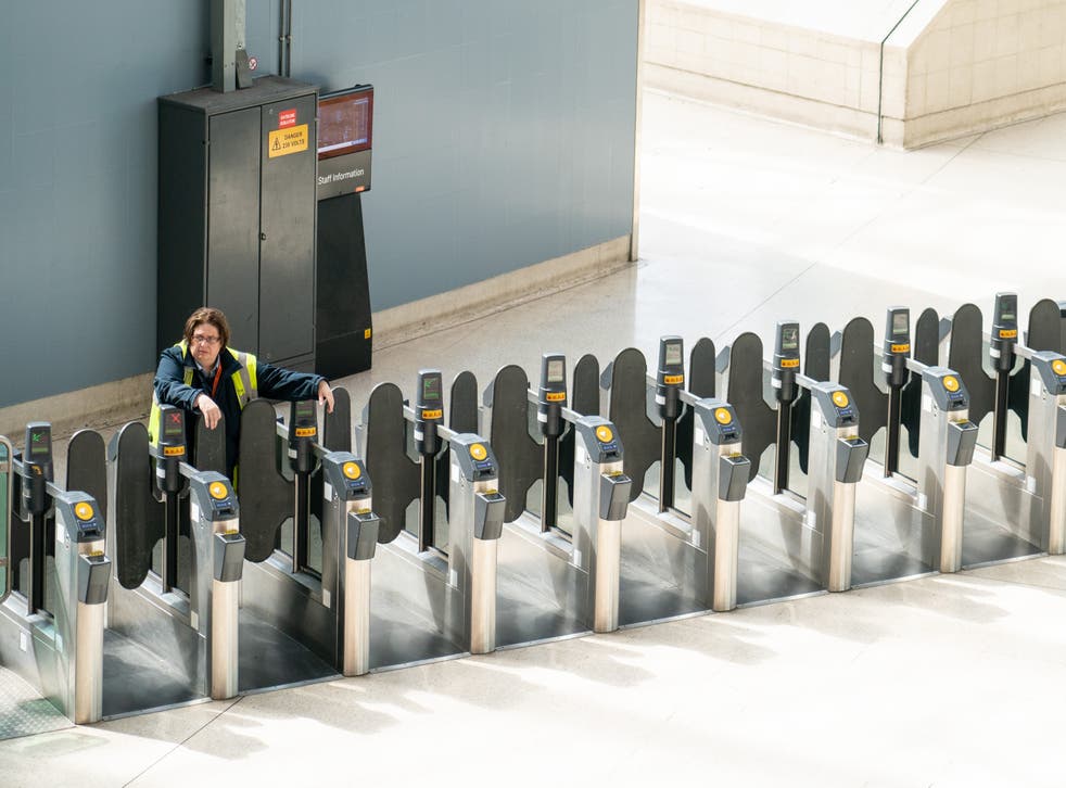 A staff member waits by ticket barriers at Waterloo station, 伦敦, during the nationwide strike by members of the Rail, Maritime and Transport union back in June (多米尼克·利平斯基/PA)