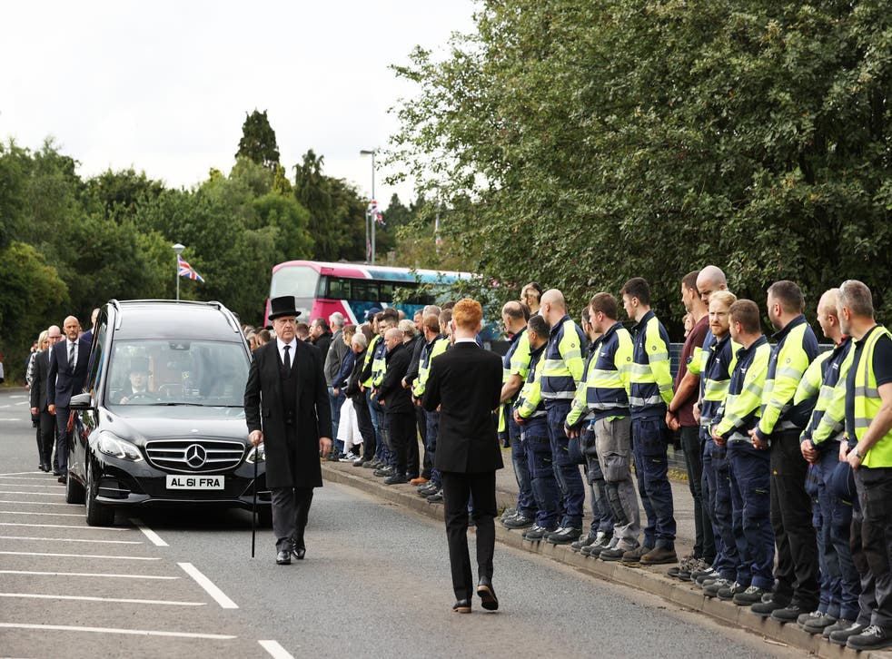 Employees stand outside the Wrightbus factory in Ballymena, as they watch the passing cortege (リアム・マクバーニー/PA)