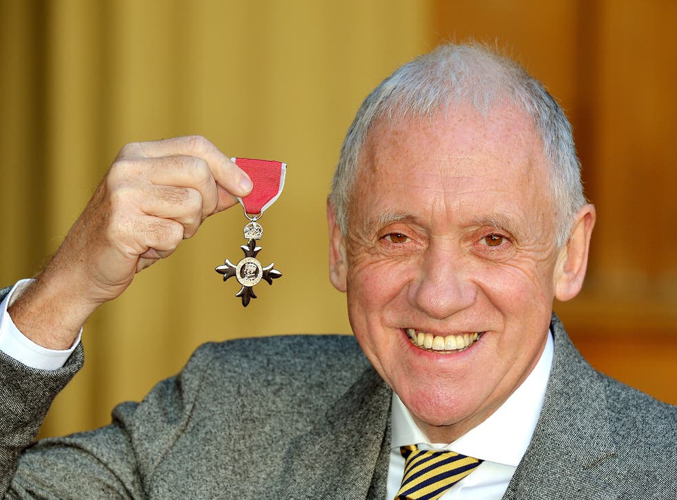 <p>Harry Gration holding his MBE</磷>