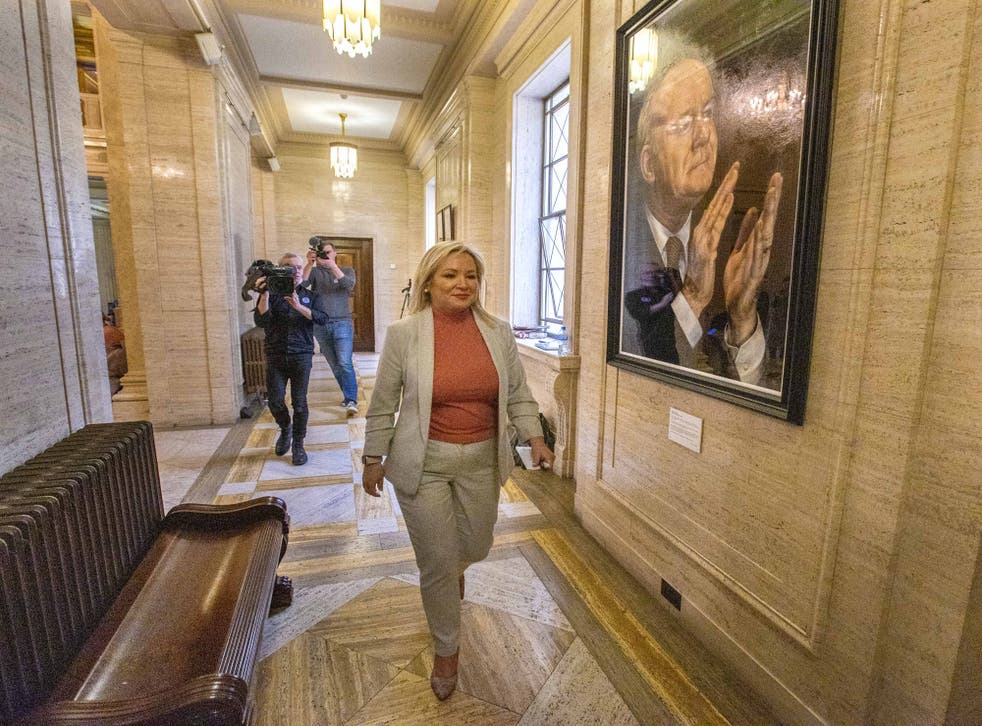 Sinn Fein vice president Michelle O’Neill walks passed a portrait of former Deputy First Minister Martin McGuinness hanging in the Great Hall of Parliament Buildings at Stormont (リアム・マクバーニー/PA)