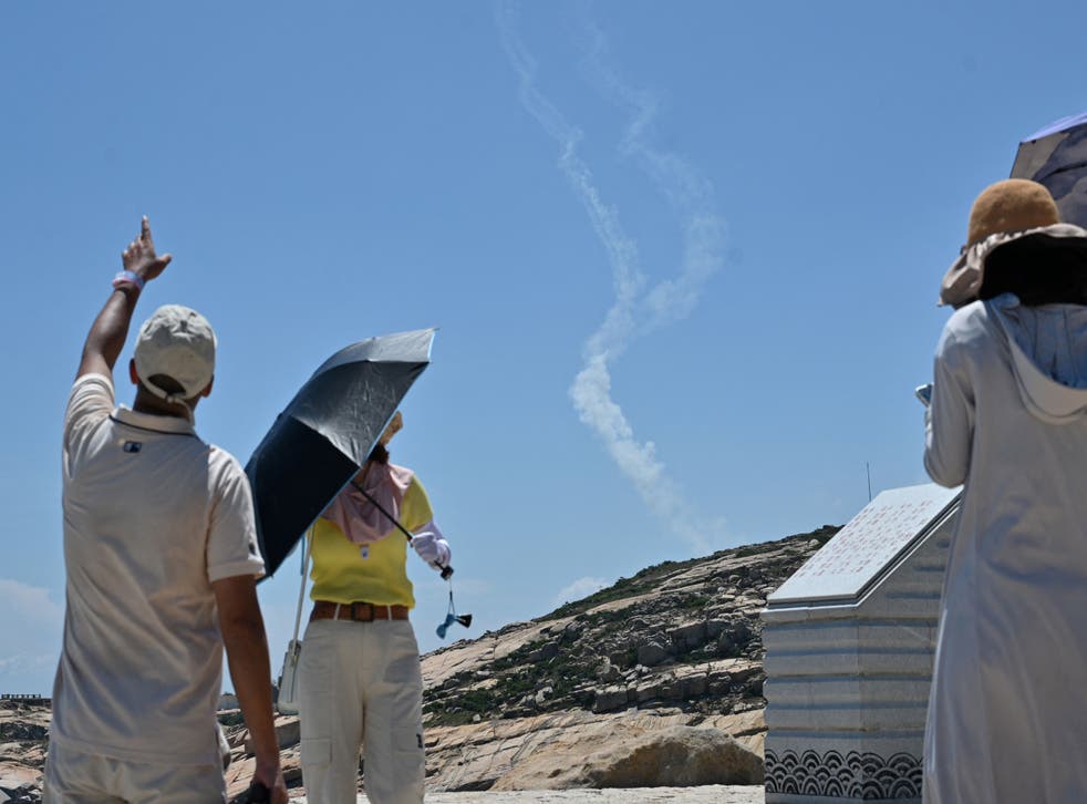 <p>Tourists on Pingtan island watch smoke trails from missiles launched by China </p>