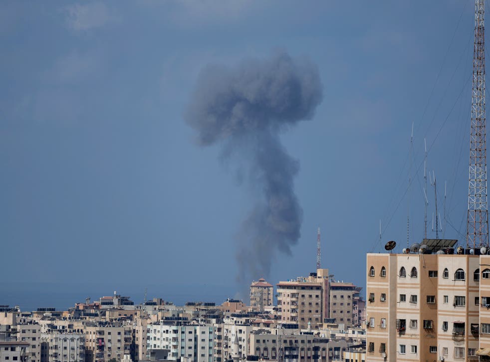 <p>Smoke rises following Israeli airstrikes on a building in Gaza City on Saturday</磷>