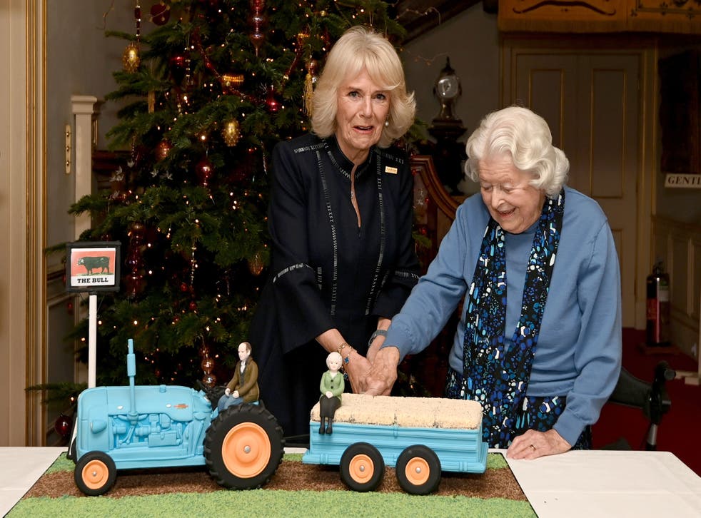 Duchess of Cornwall (left) and June Spencer cut an Archers themed cake during a reception to celebrate the 70th anniversary of the programme at Clarence House (Kate Green/PA)