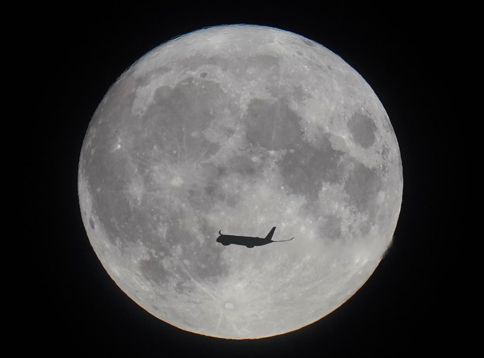 A plane is seen silhouetted against the supermoon in London (Yui Mok/PA)