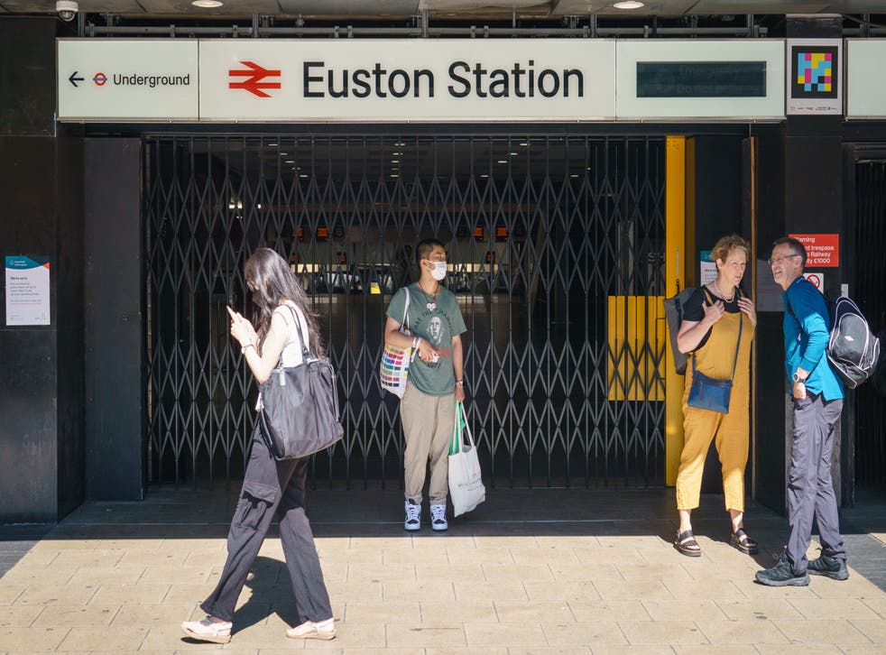 People stand outside the closed entrance to Euston station in London (ドミニク・リピンスキー/PA)