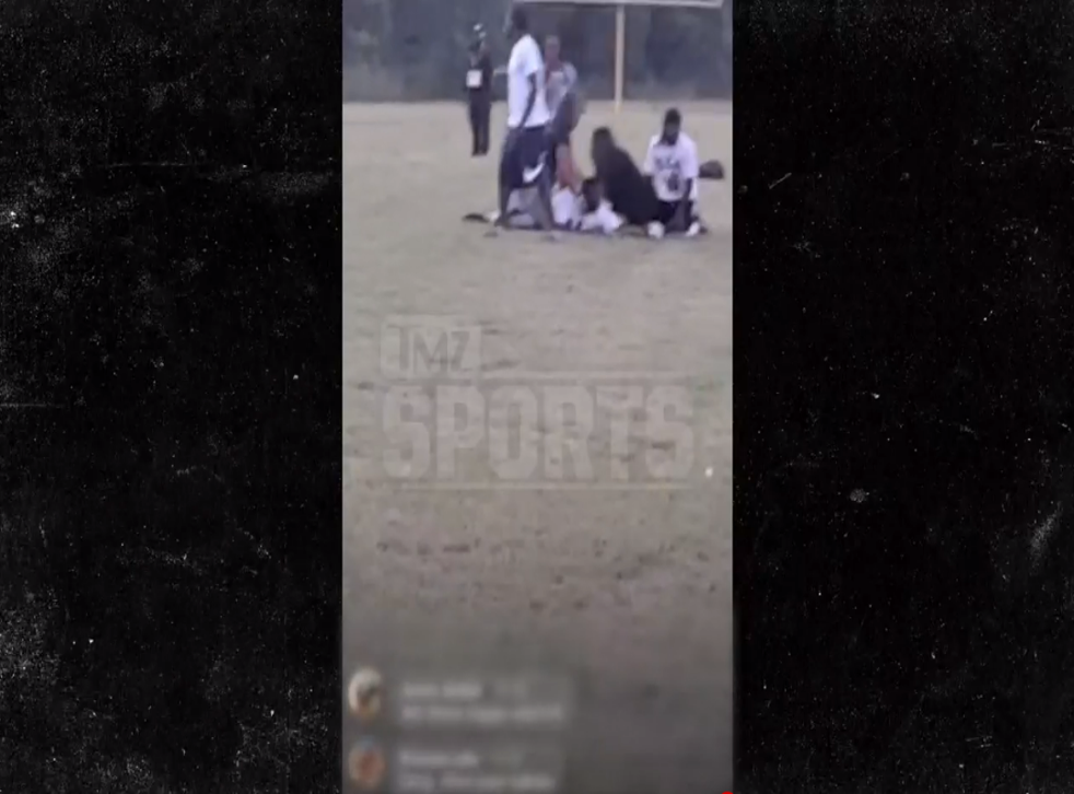 <p>Attendees at a youth football game in Texas can be seen tending to a person who appears to have been hurt after gunshots were fired at a Saturday night game outside of Dallas</p>