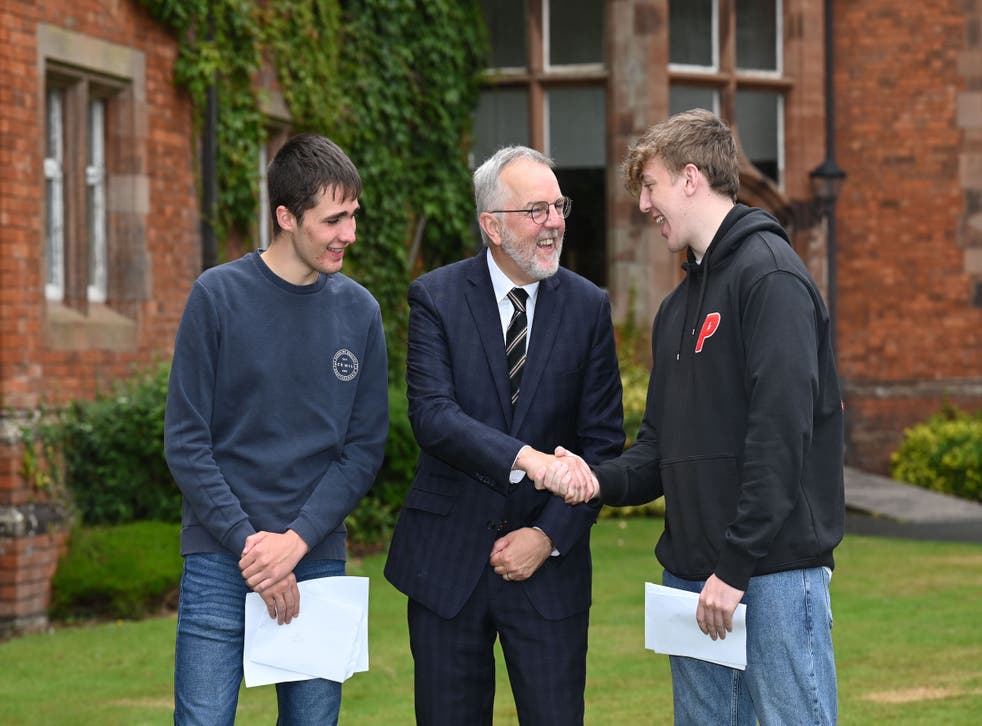 Campbell College headmaster Robert Robinson congratulates A-level students Patrick Kenny and Tom Crowther (Michael Cooper/PA)