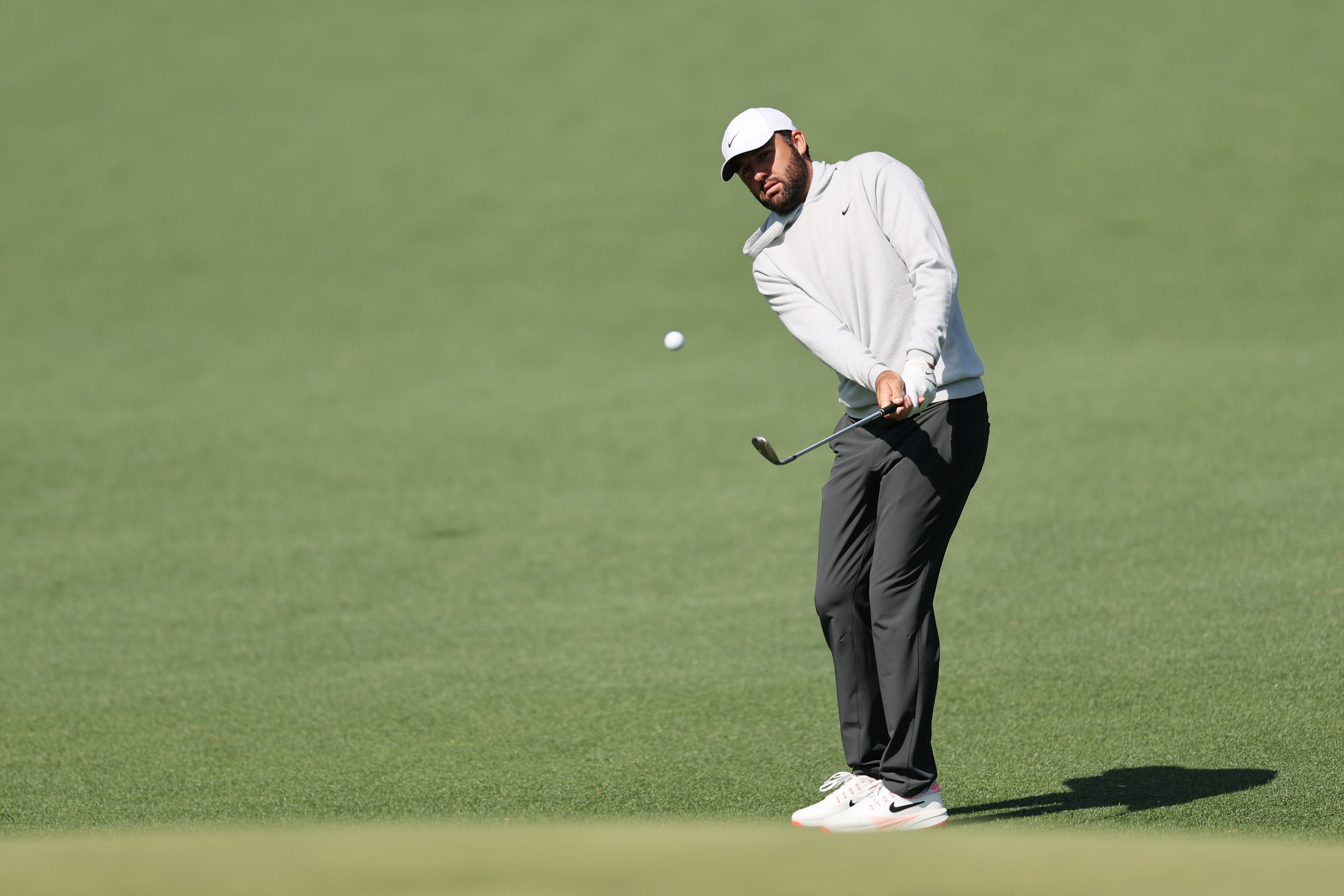 Scottie Scheffler of the United States chips on the 14th hole