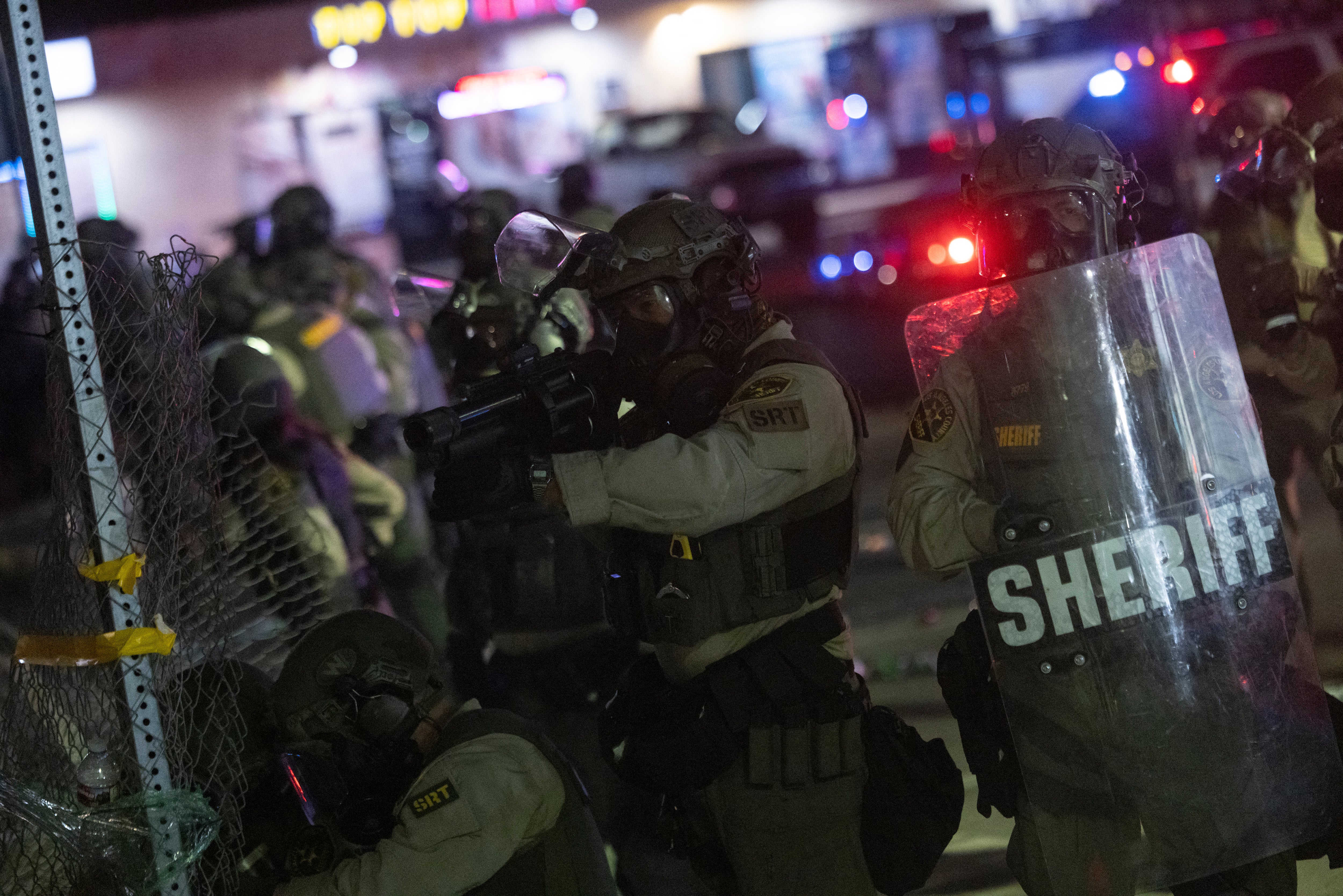 Law enforcement clash with demonstrators during a protest following federal immigration operations