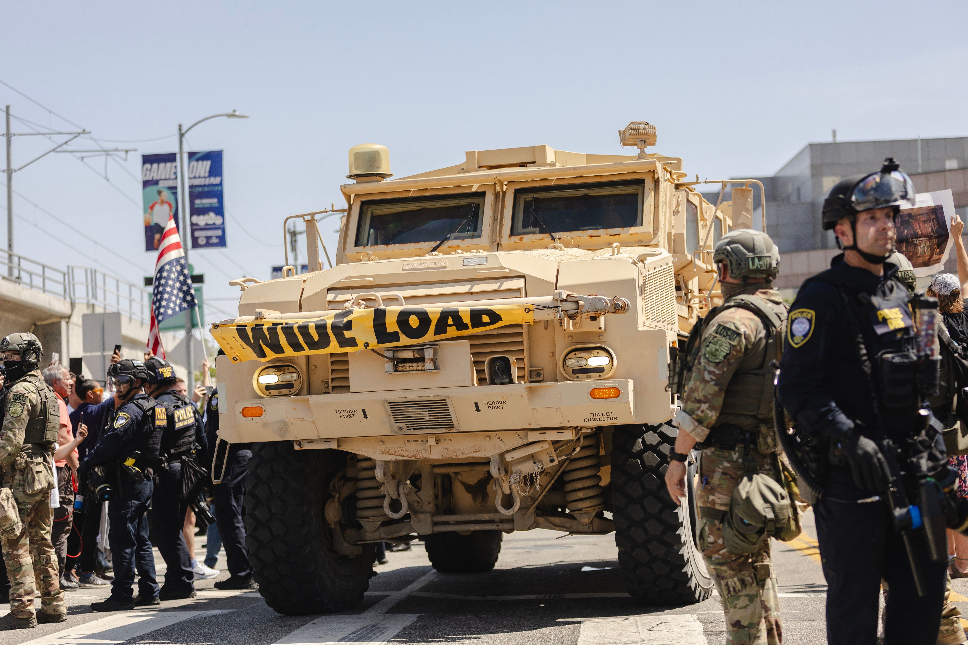 An armoured vehicle drives passed a police line outside of the Metropolitan Detention Center on June 10