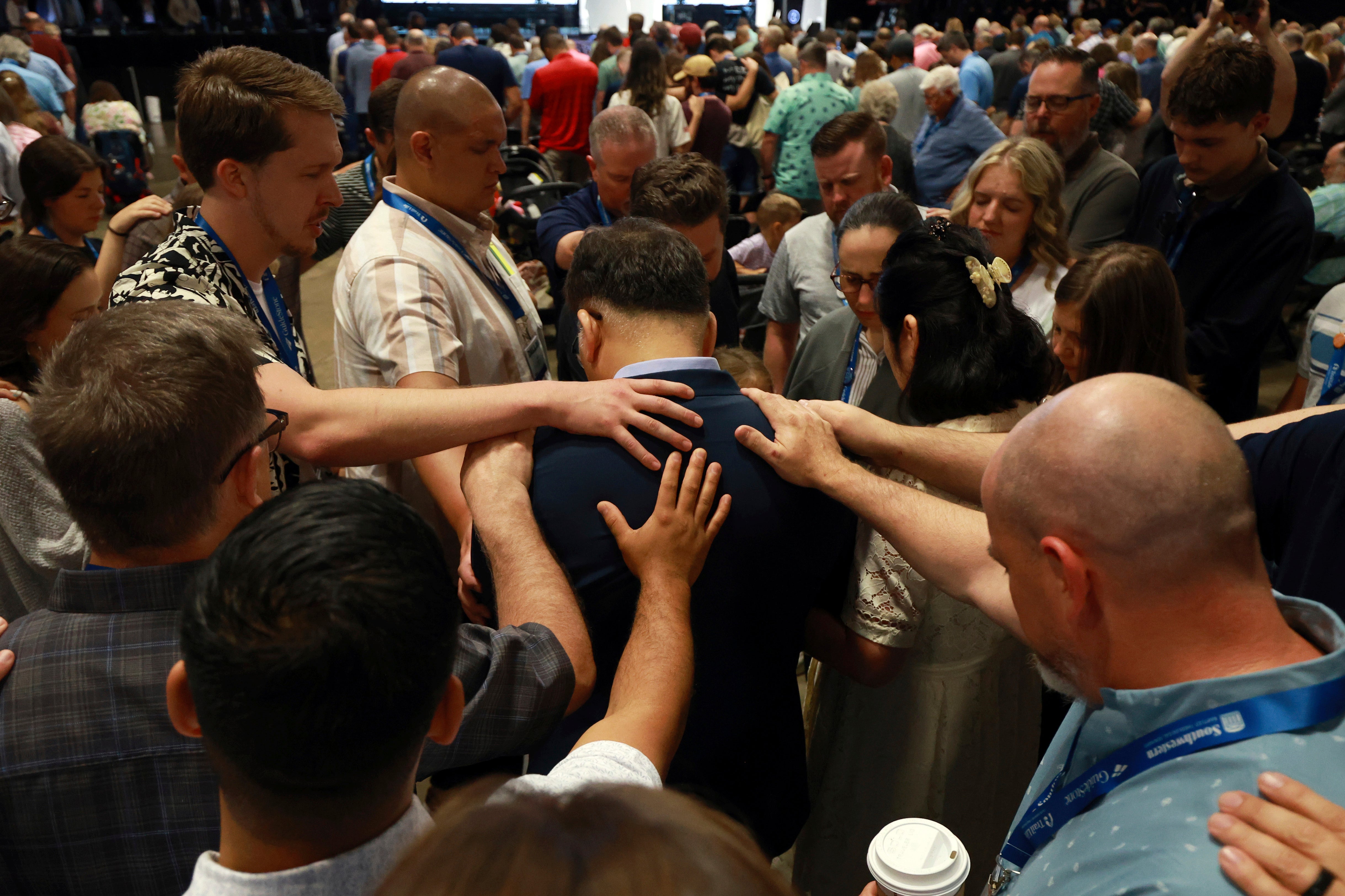 Messengers attending the Southern Baptist Convention lay on hands and pray over missionaries