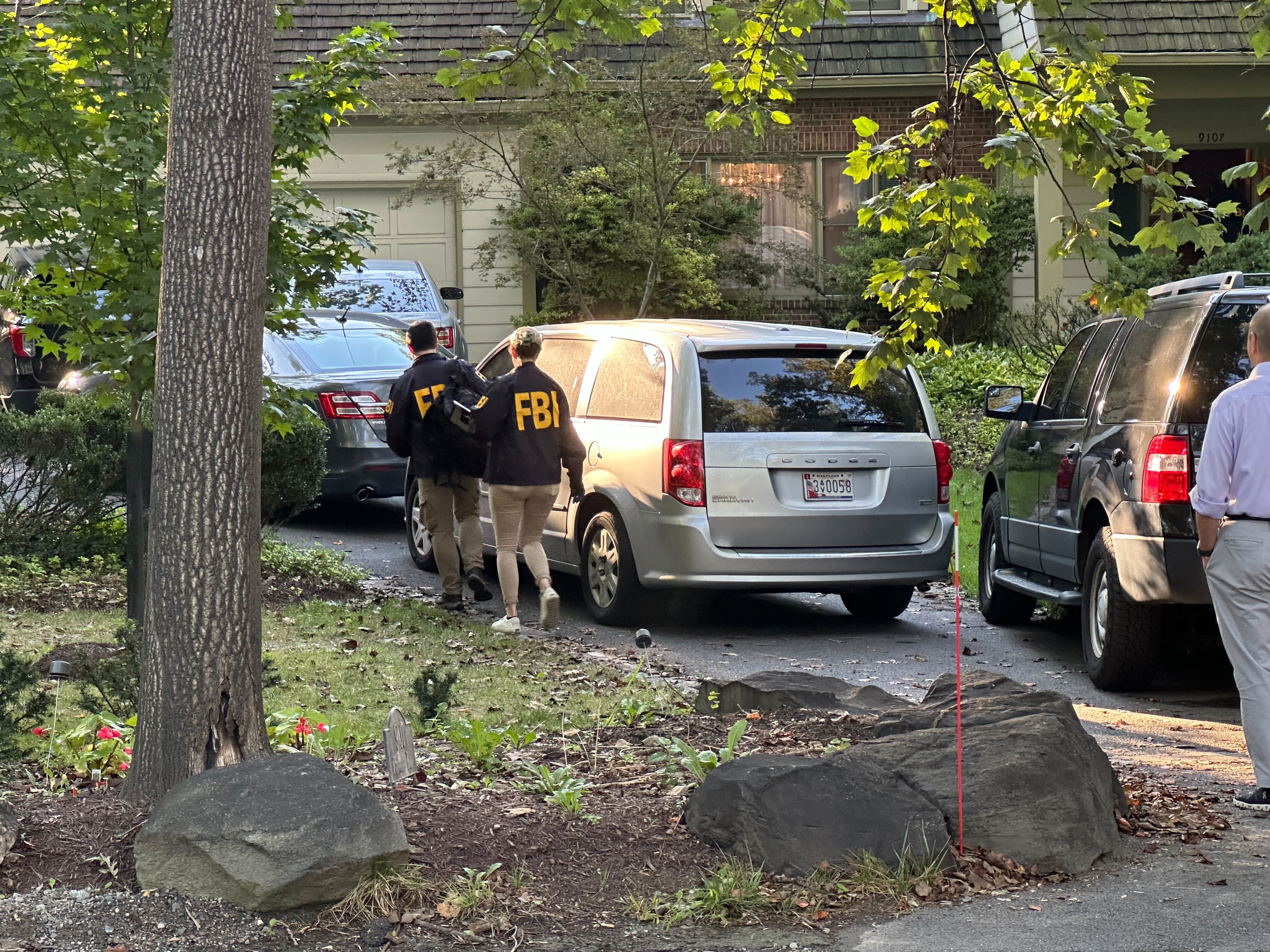 FBI agents are seen outside the home of former national security adviser John Bolton.
