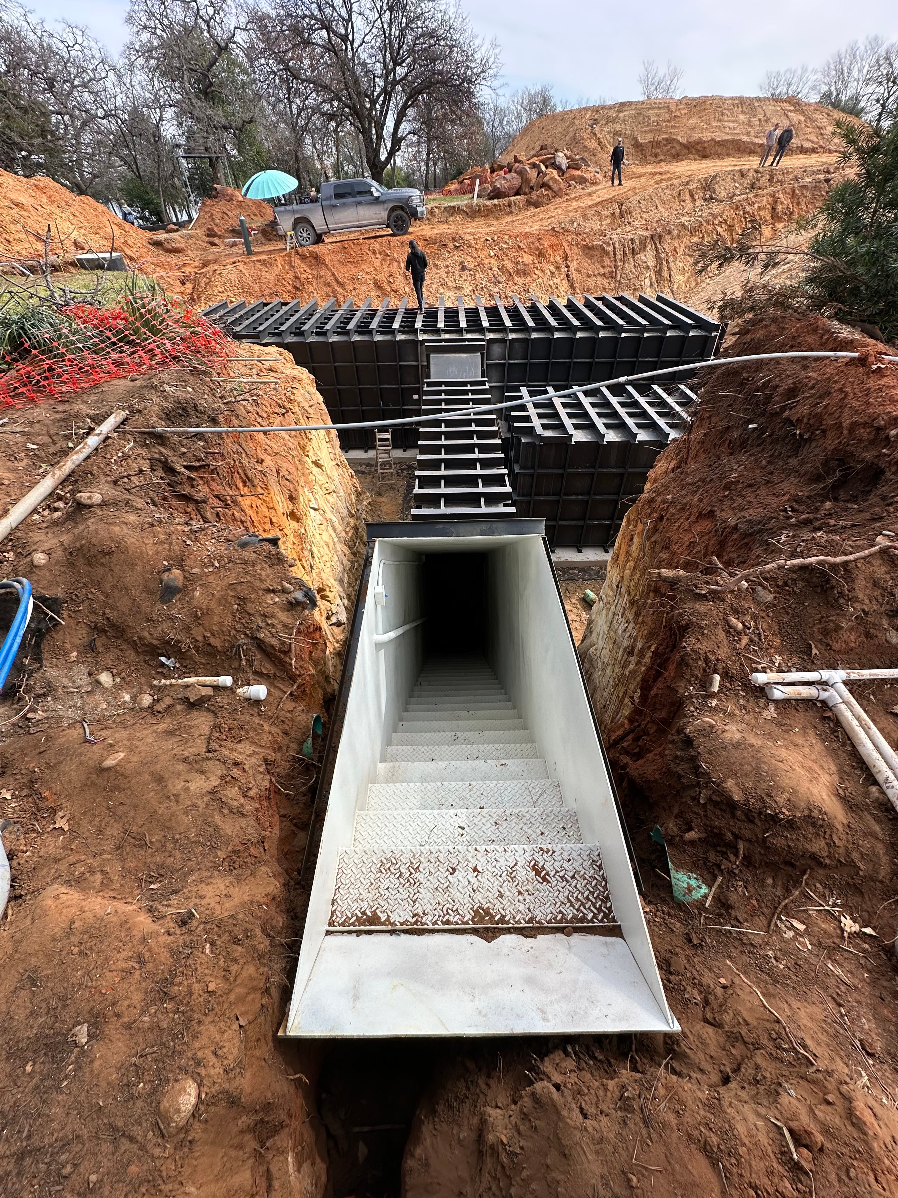 An Atlas Survival Shelter bunker being inserted into the ground, where it will be concreted over and then become connected to the house on top of it by the escape hatch