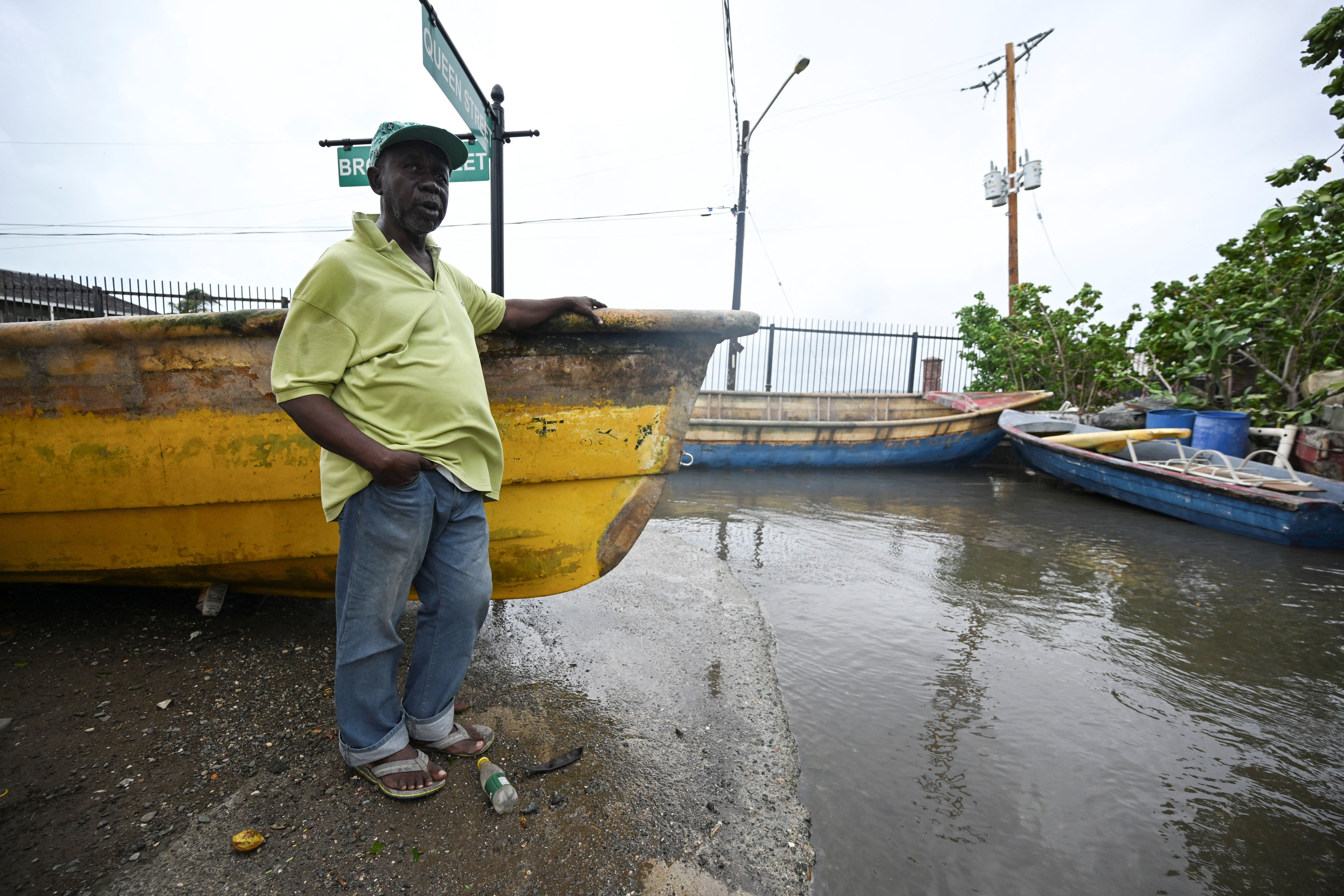 A resident stands at a flooded section of Port Royal on Monday