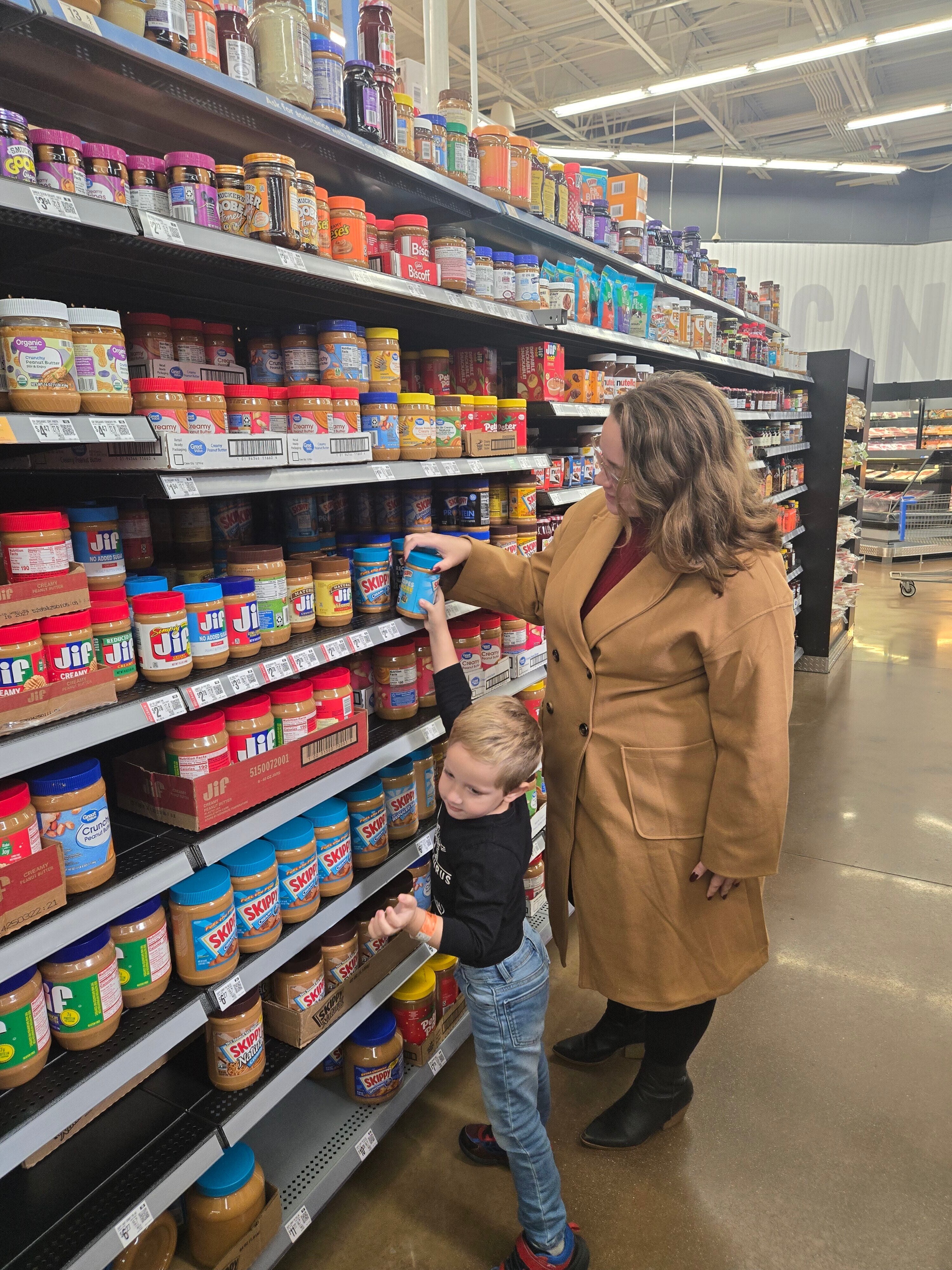 Emily Archambault and her son shop for shelf-stable food to give out to to trick-or-treaters