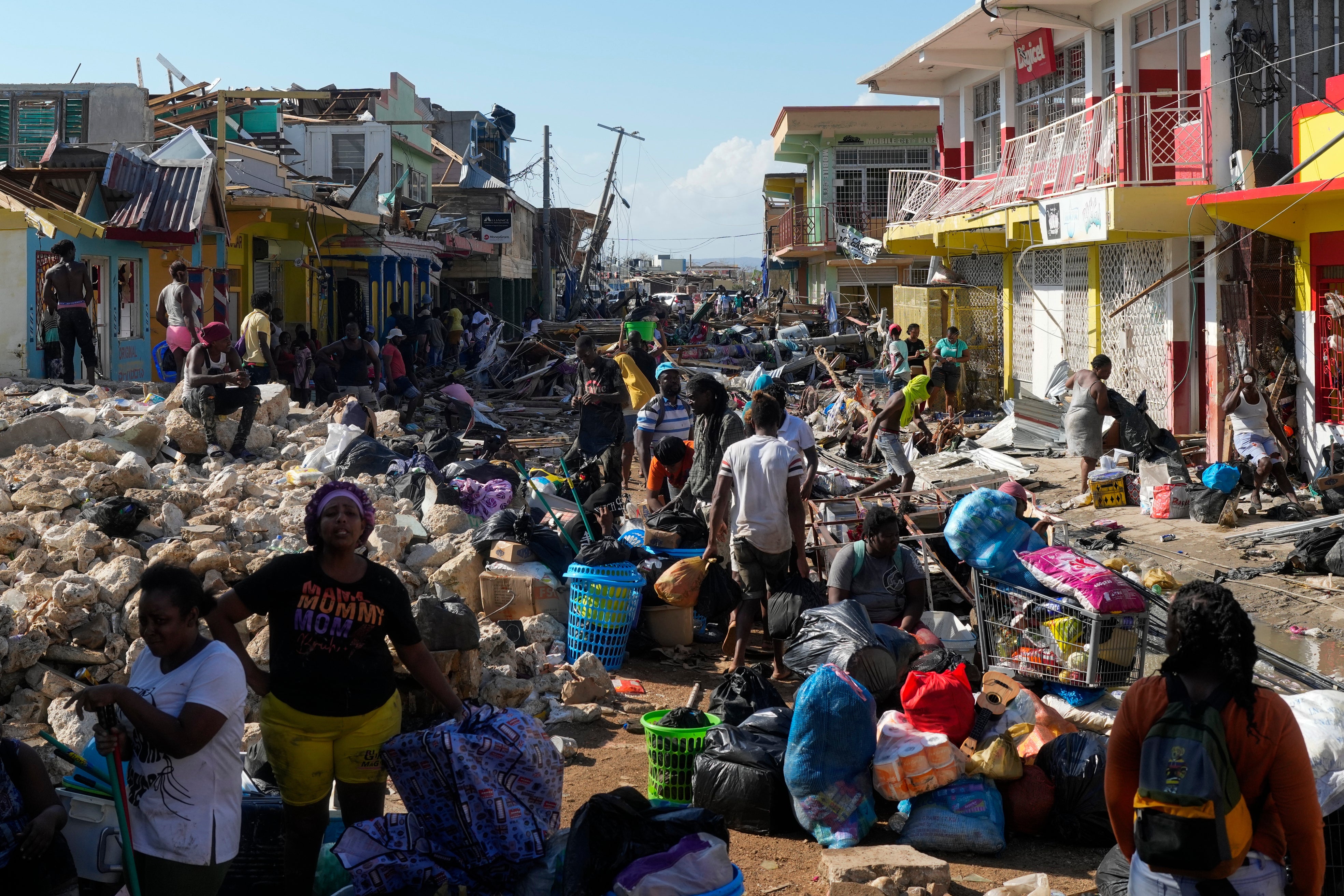 Residents gather amid debris in Black River, Jamaica, in the aftermath of Hurricane Melissa
