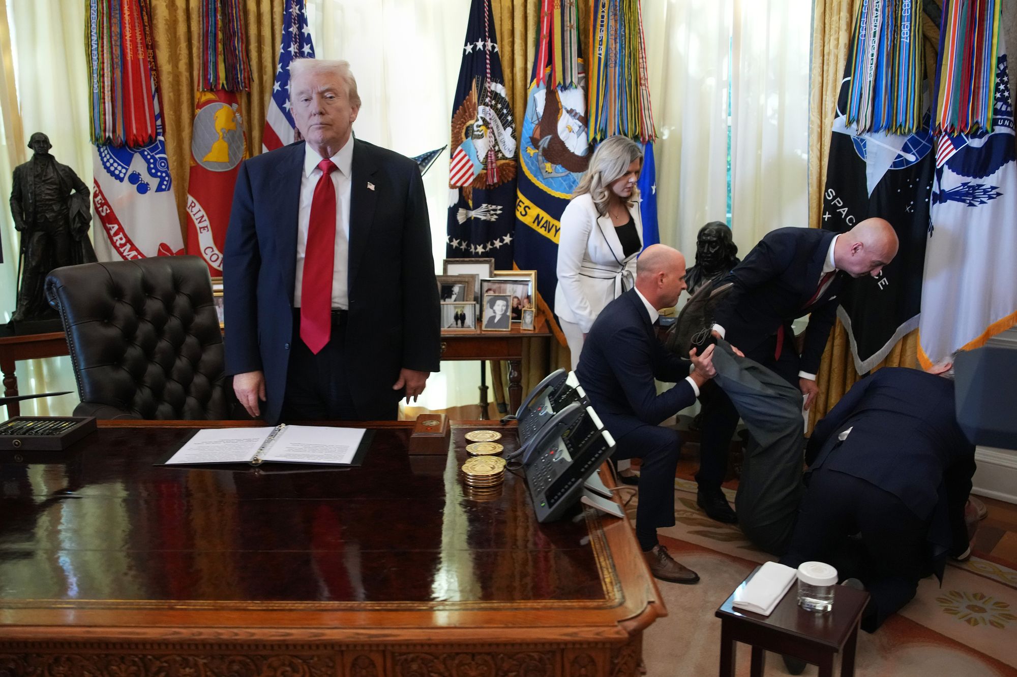 President Trump standing behind the Resolute Desk after a pharmaceutical executive collapsed during a press conference