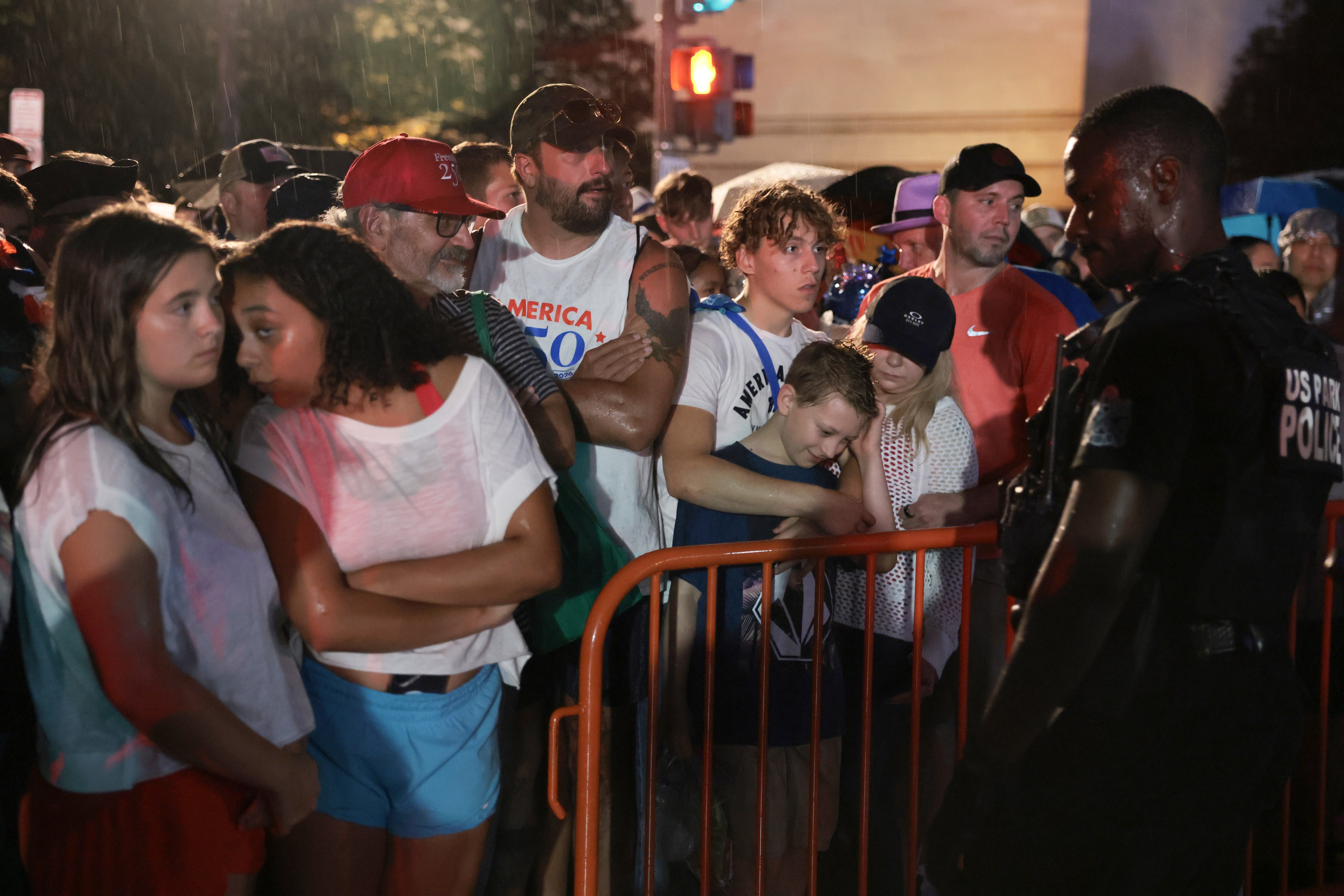 Many attendees clustered near barricades in the rain as officers encouraged people to disperse and take shelter