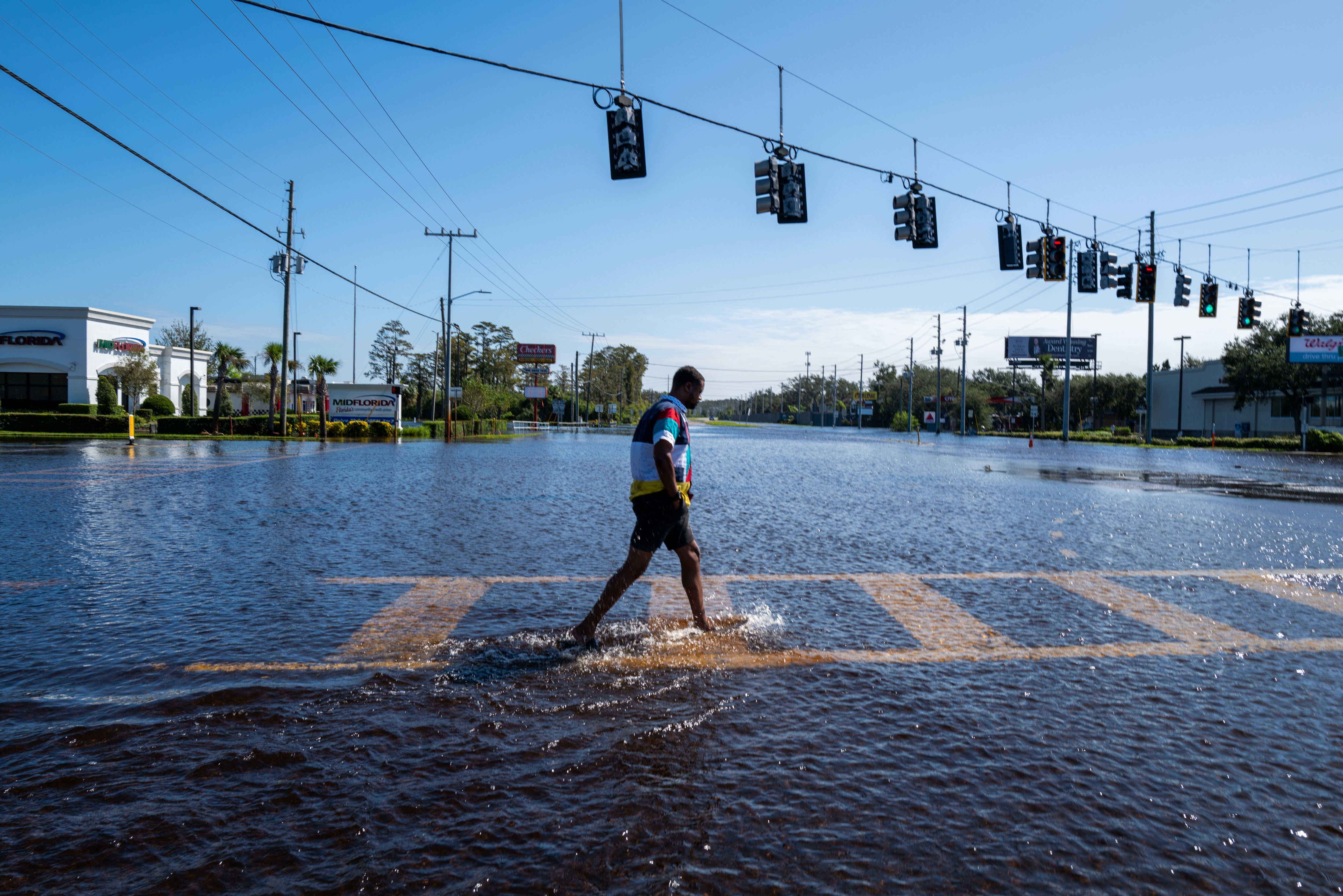 A person walks through a flooded street in New Port Richey, Florida, following Hurricane Milton in October 2024. There was an unusually high number of vibriosis cases after the hurricane