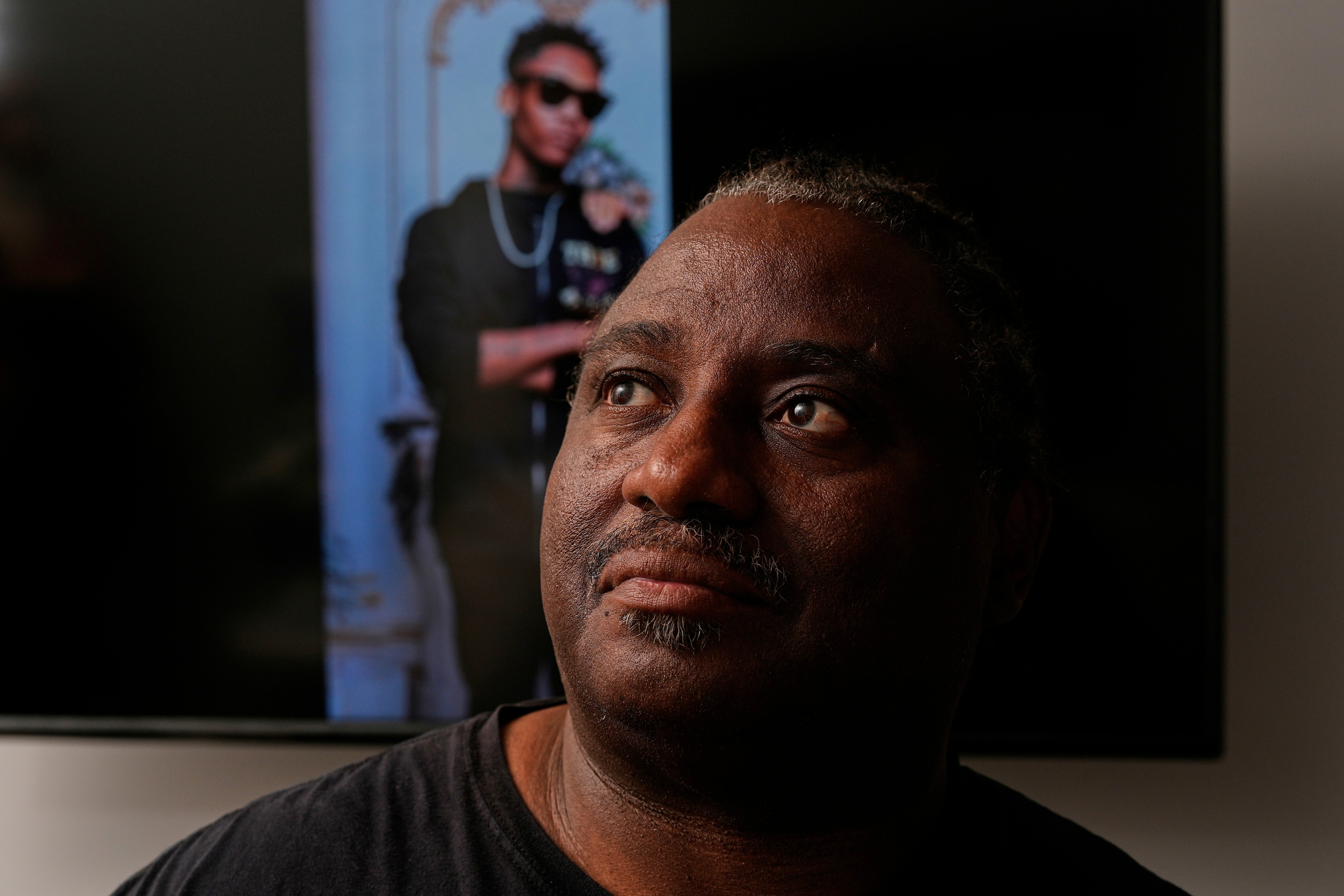 Evaniel Johnson poses with a picture of his grandson, Tyrin