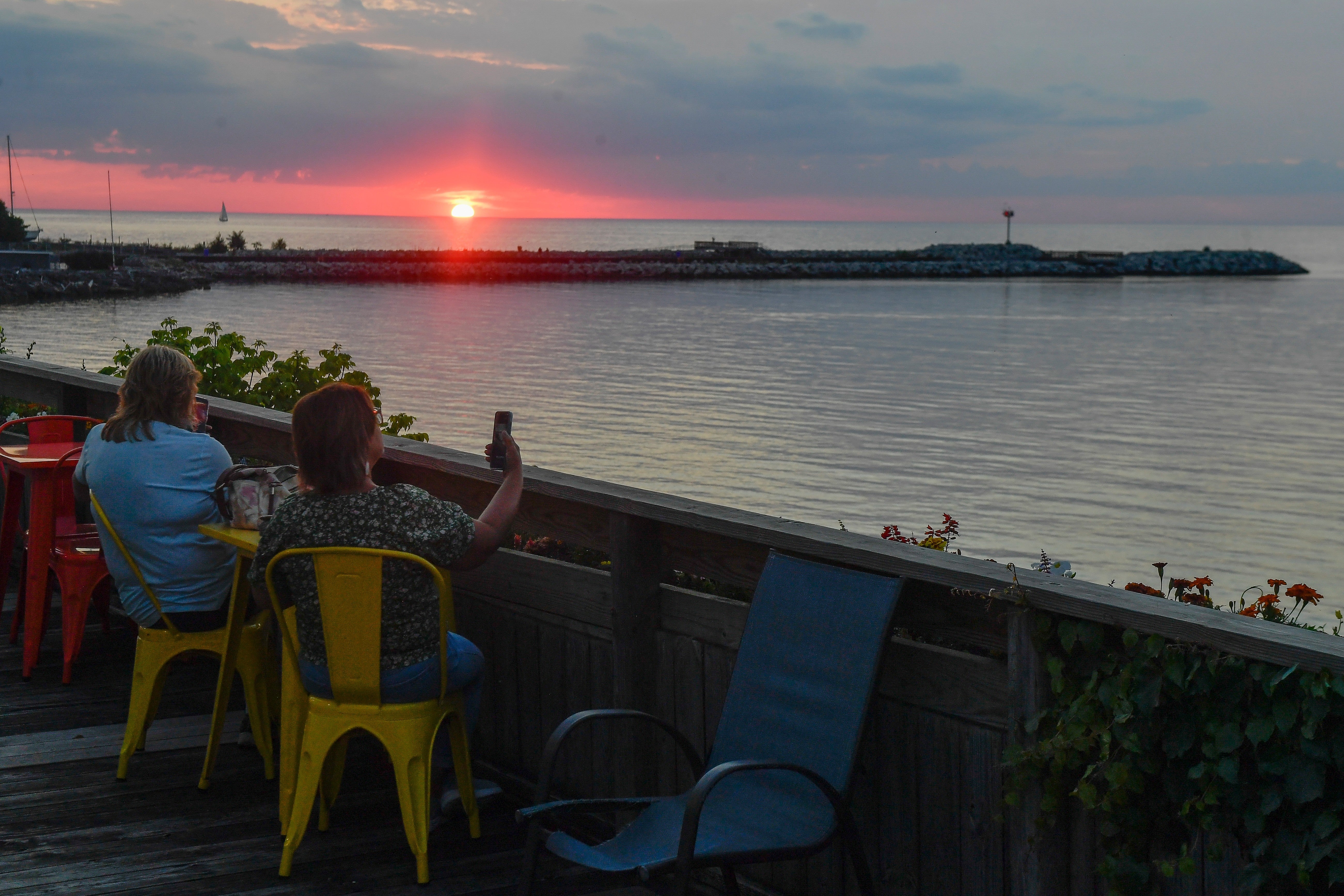 People watch the sun set over Lake Ontario