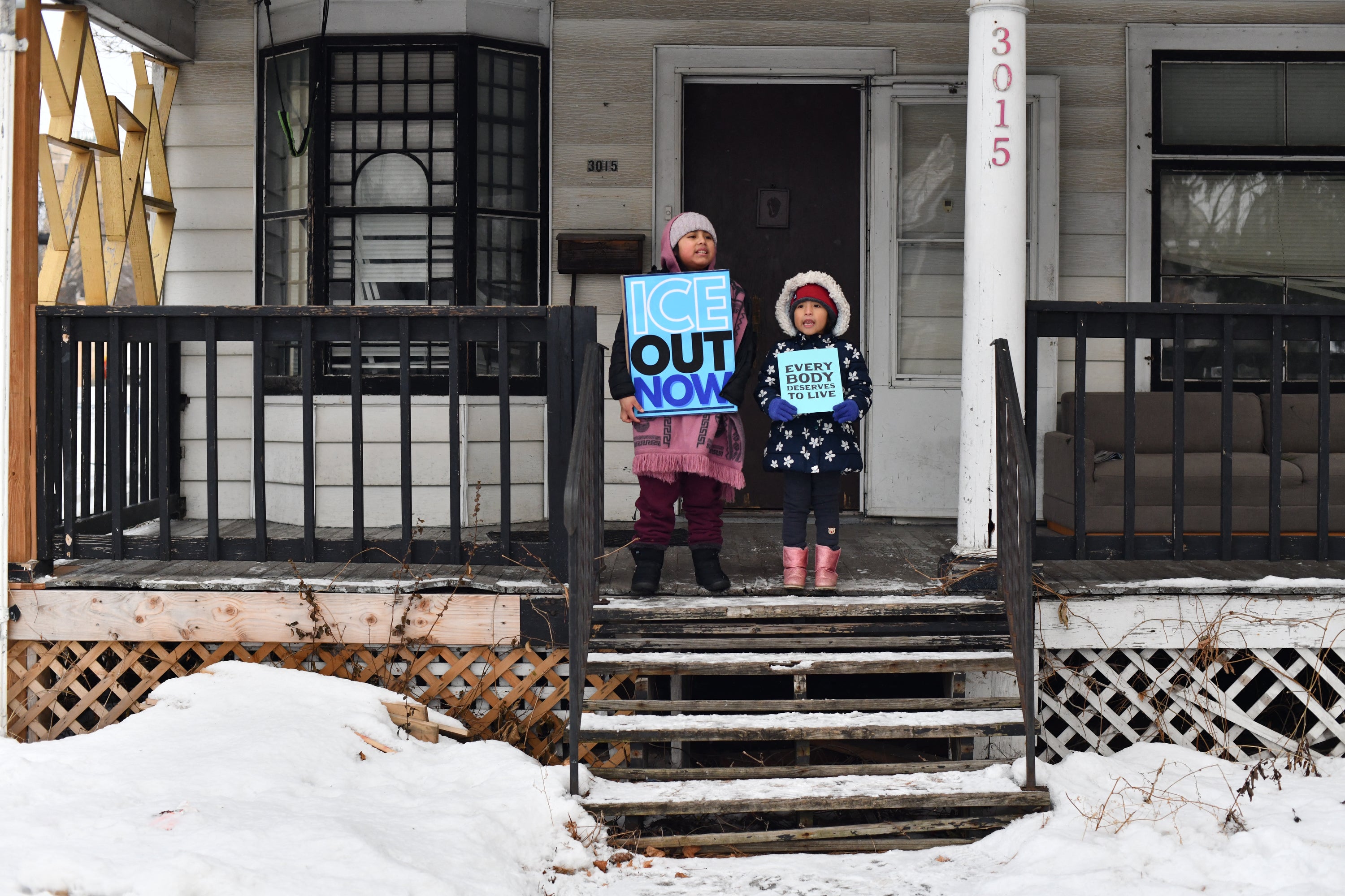Children hold signs on the stoop of a house as protesters march from Powderhorn Park in Minneapolis against Immigration and Customs Enforcement (ICE) and the fatal shooting of Renee Good by an ICE agent. Beyond chronic absenteeism, teachers describe students shutting down mid-exam or crying during class during peak winter operations