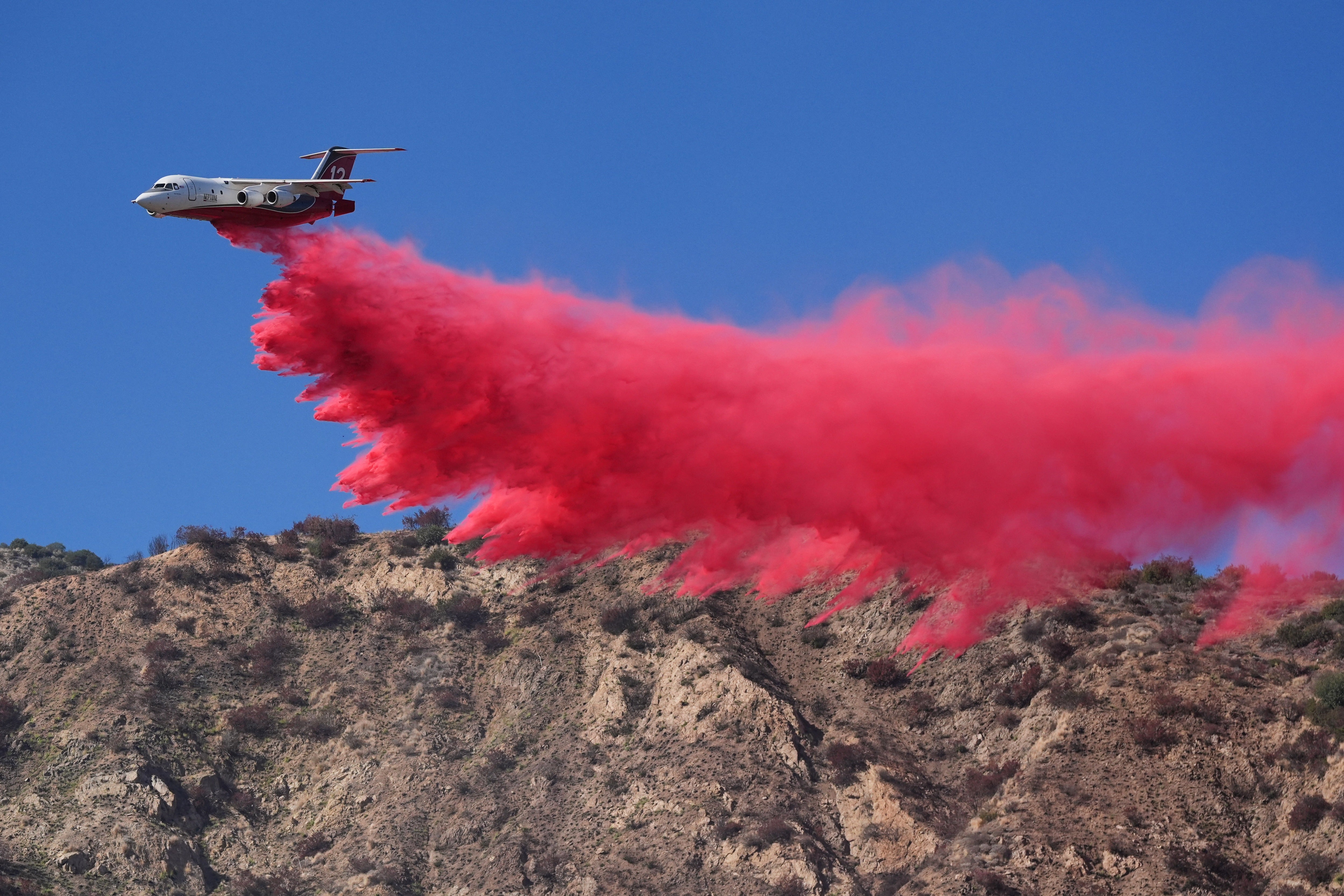 A tanker drops retardant on the Peak Fire
