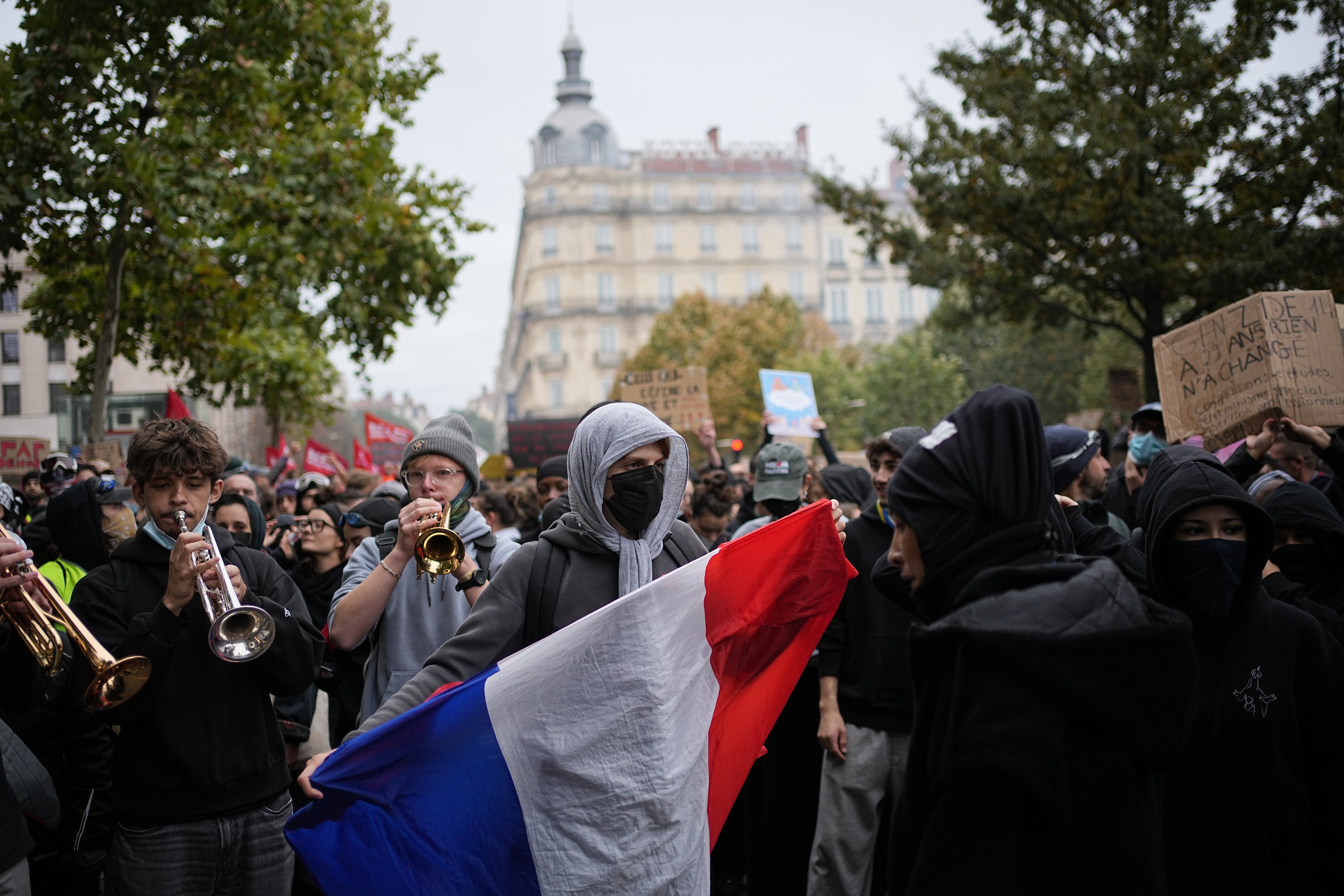 A protesters holds a French flag during a demonstration against rising living costs, joining students' grievances, in Lyon, France, Saturday, Oct. 17, 2026