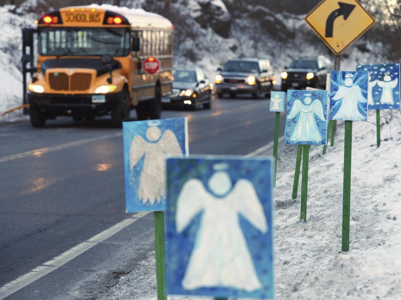 A bus traveling from Newtown to Monroe stops in front of 26 angels along the roadside on the first day of classes for Sandy Hook Elementary School students since the Dec. 14, 2012 shooting.