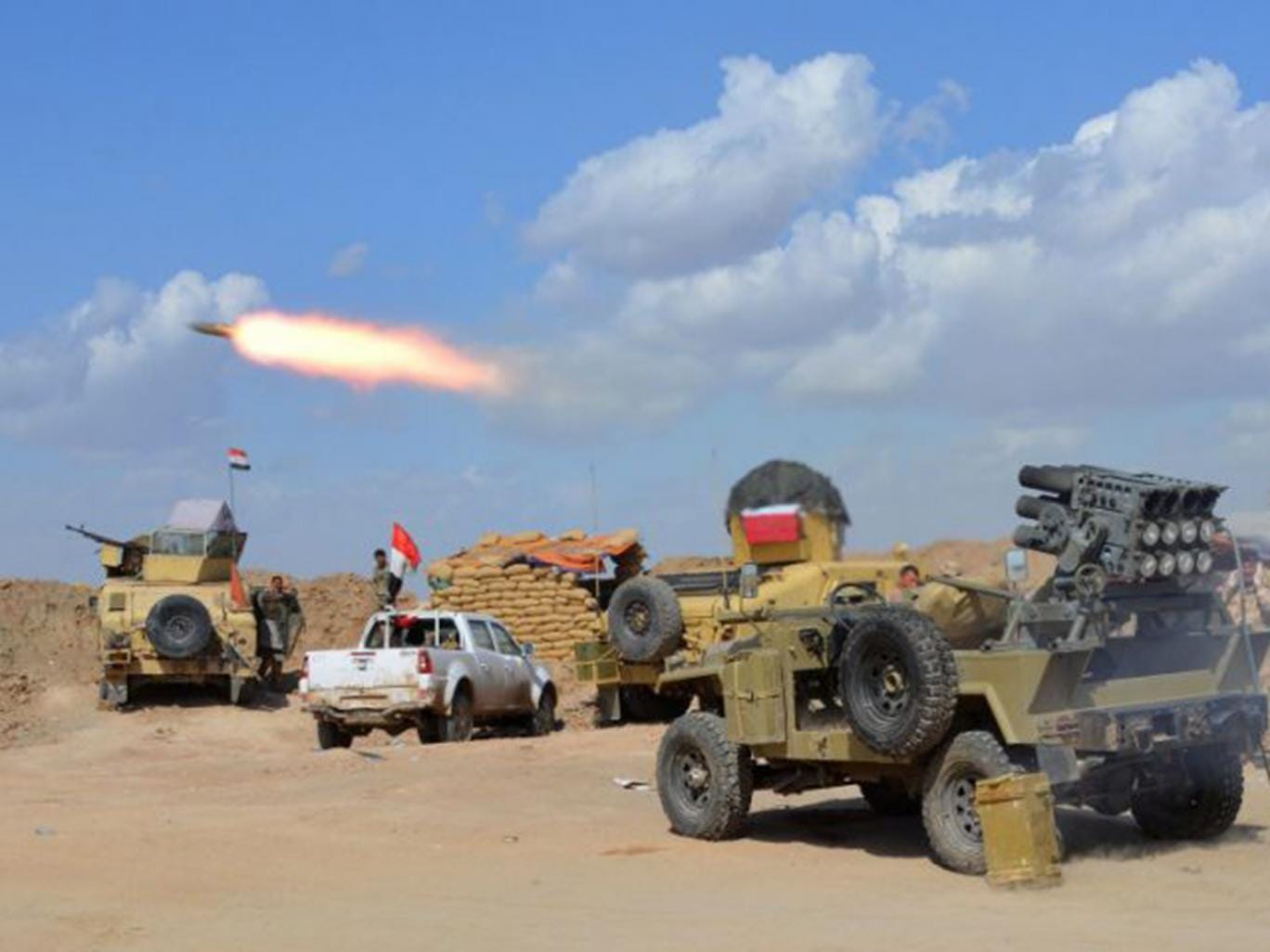 Iraqi government forces and allied militias firing weaponry from a position in the northern part of Diyala (AFP)
