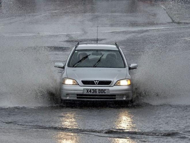 A car driving through flood water as a heavy storm passes through Cullercoats in North East England. 