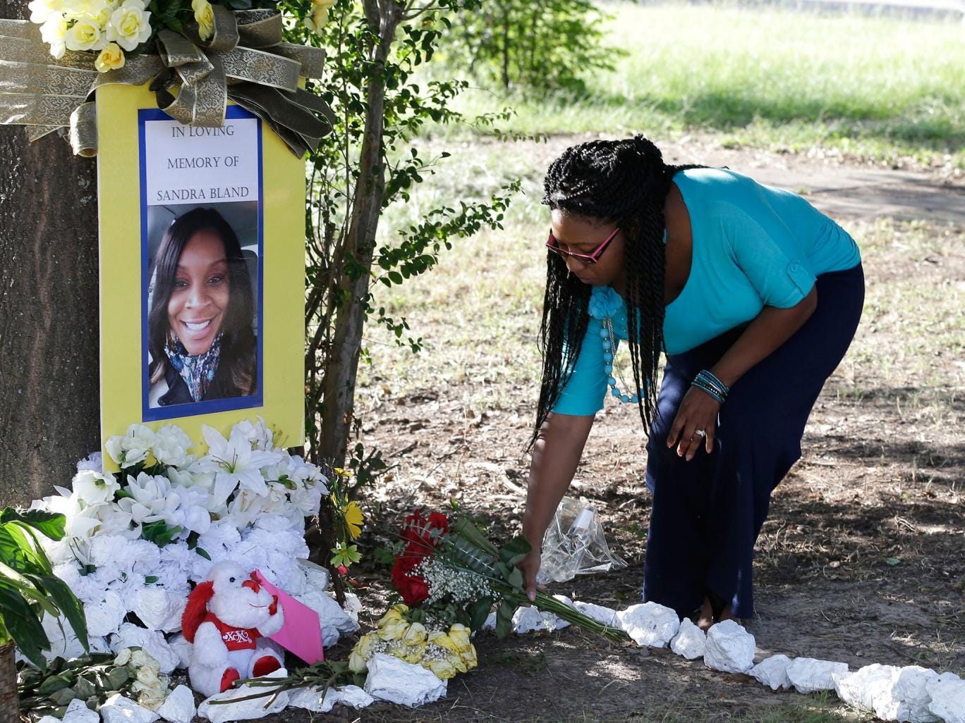 Jeanette Williams places a bouquet of roses at a memorial for Sandra Bland near Prairie View A&amp;M University, Tuesday, July 21, 2015, in Prairie View, Texas (AP)