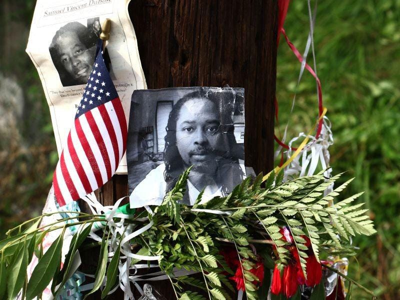 Photos of Samuel DuBose hang on a pole at a memorial in Cincinnati