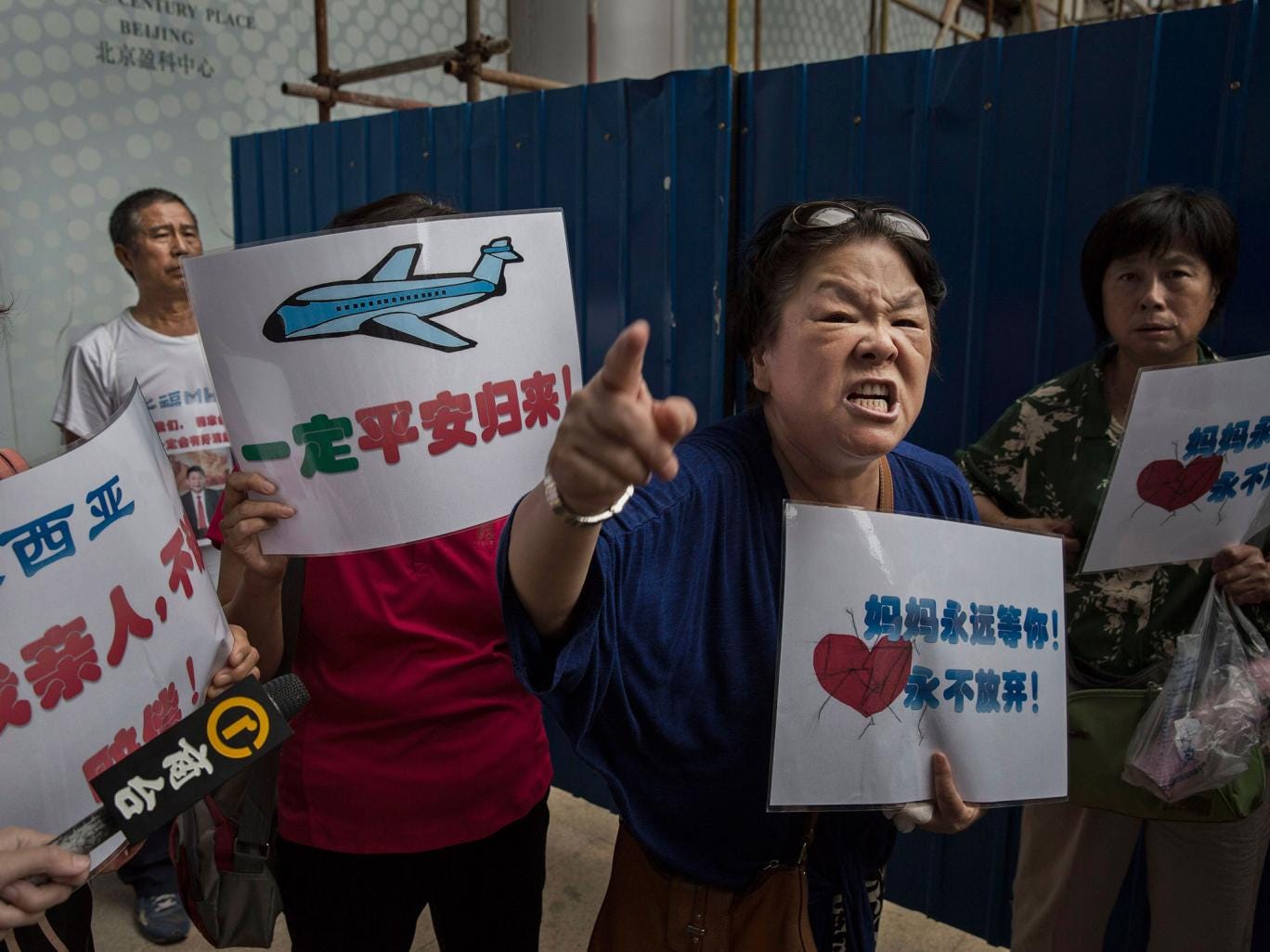 A Chinese relative of a missing passenger on Malaysia Airlines flight MH370 outside the airline's Beijing office on 6 August, 2015