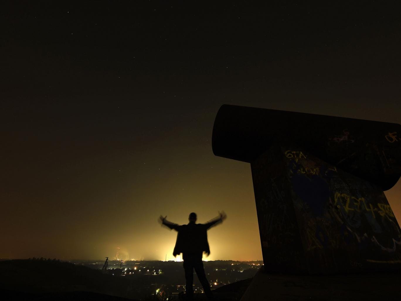 A man waits for the Perseid meteor shower at night on a mining dump in Gelsenkirchen, western Germany,