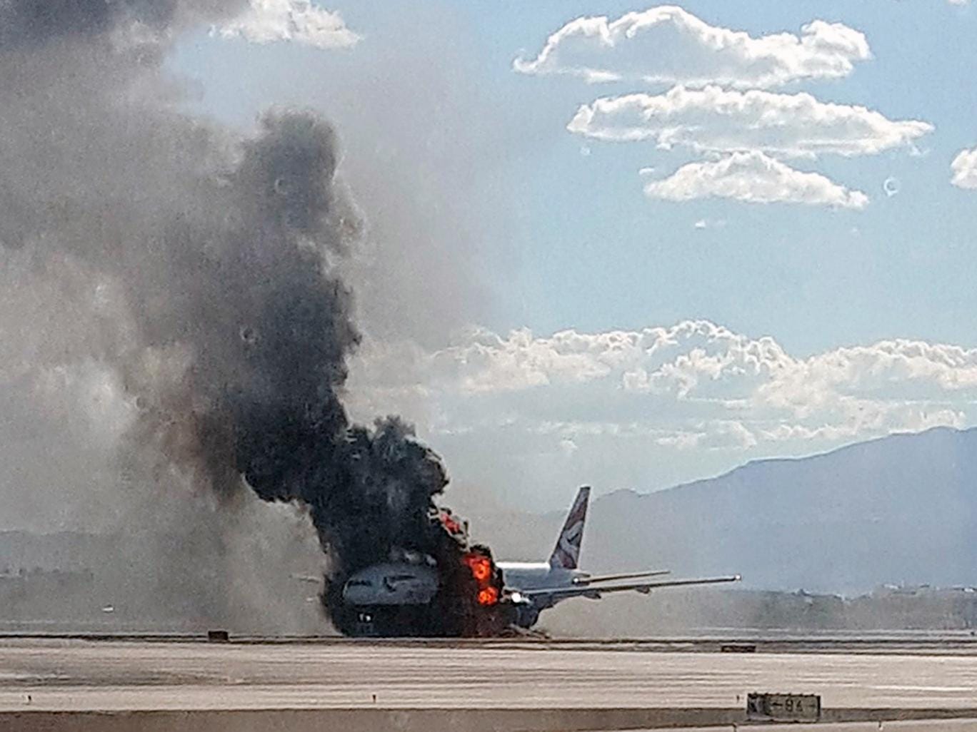 Smoke billows out from a plane that caught fire at McCarren International Airport