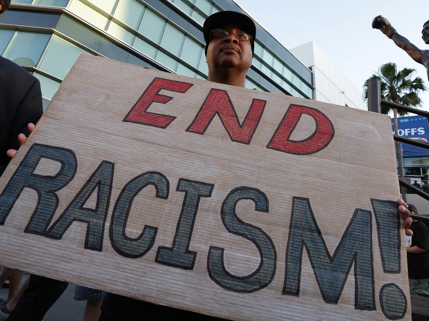 Dexter McLeod holds a sign protesting racist comments made by L.A. Clippers owner Donald Sterling outside Staples Center before a playoff game on April 29, 2014 i